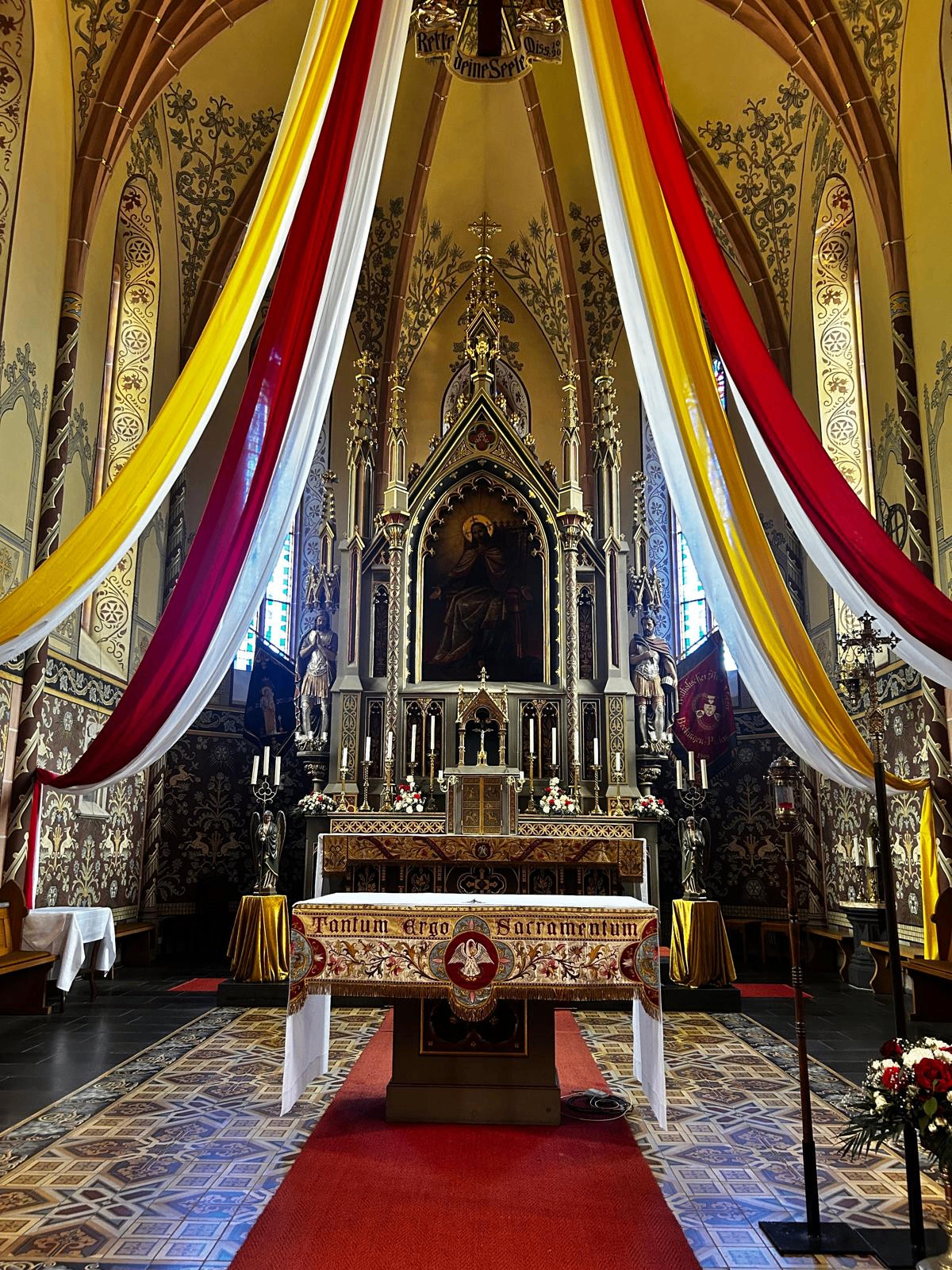 Hochaltar mit gelb-weiß-roten Tüchern und Tantum Ergo Sacramentum
